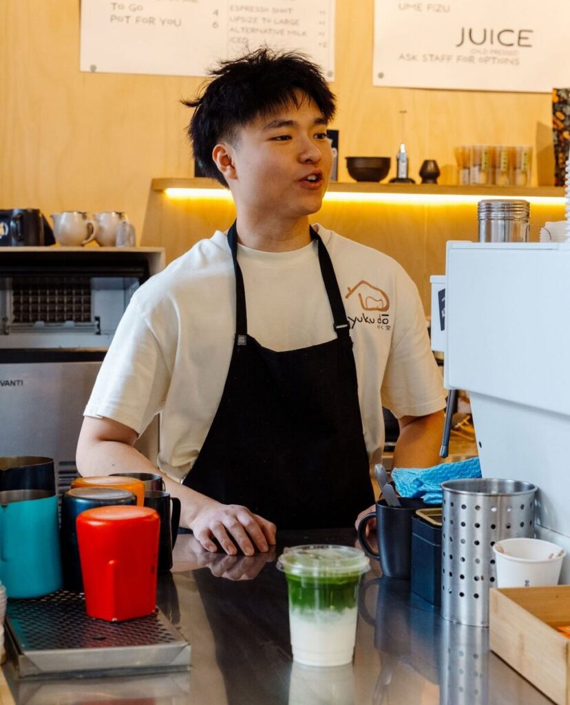 A Yuku Do barista working at the espresso machine