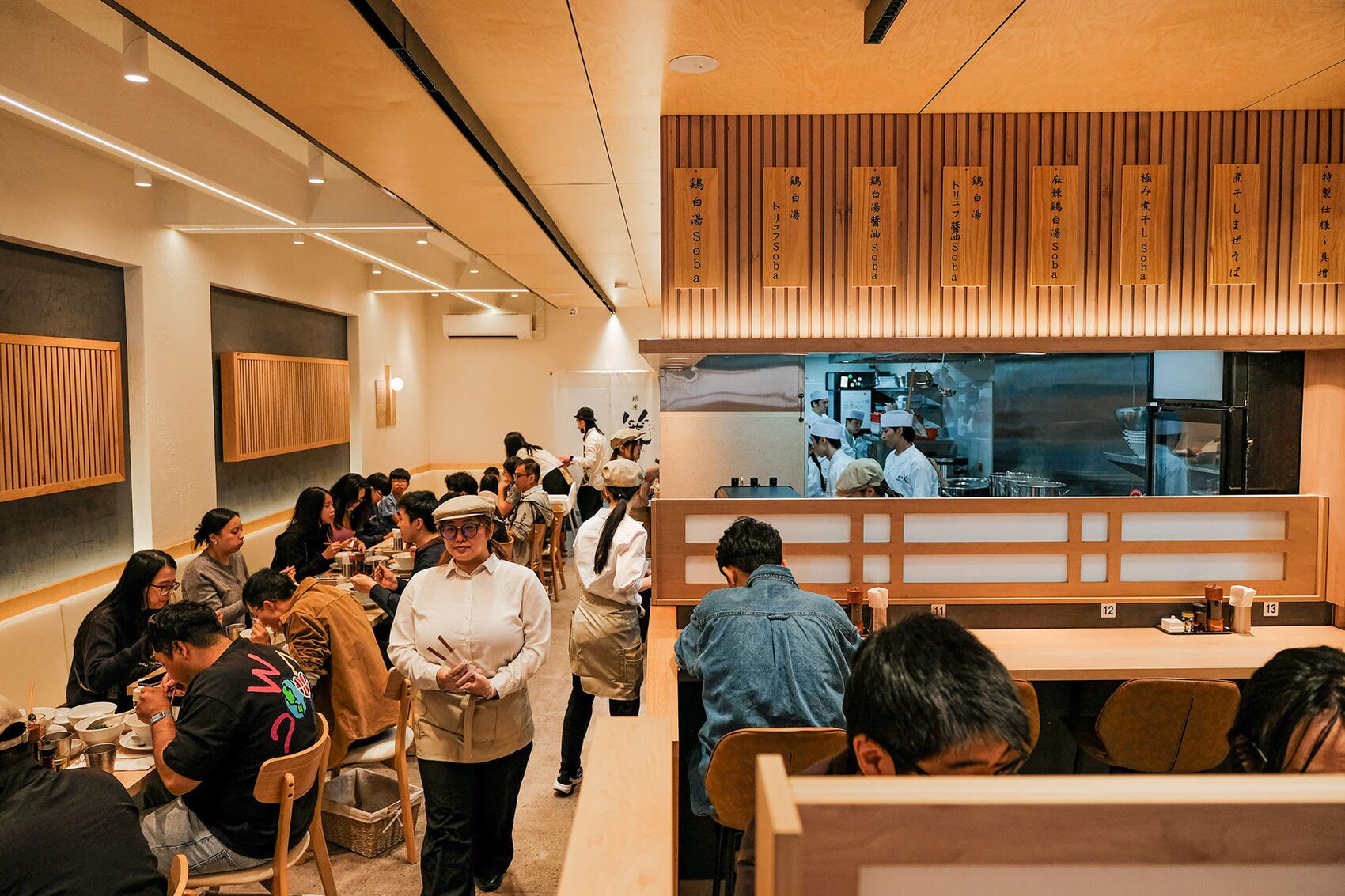 The Ginza Kagari dining hall in service, guests at the tables and chefs visible through the kitchen pass