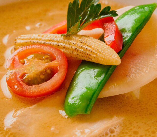 Close-up of Ginza Kagari chicken broth with tomato, baby corn and snow pea