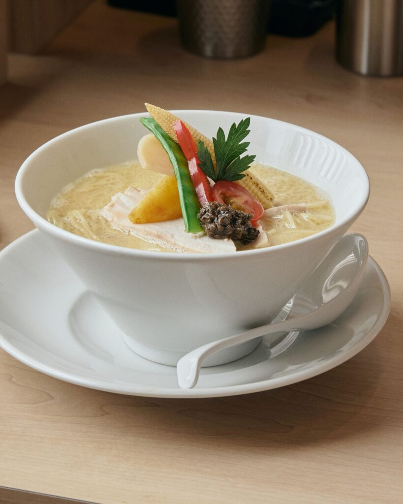 A bowl of Ginza Kagari Tori Paitan ramen with seasonal vegetables